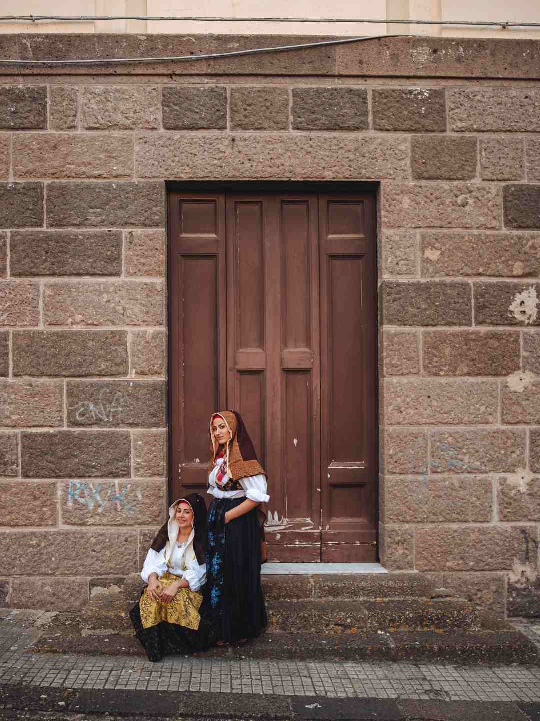 Donne con abiti tipici davanti a un palazzo durante la Cavalcata Sarda a Sassari