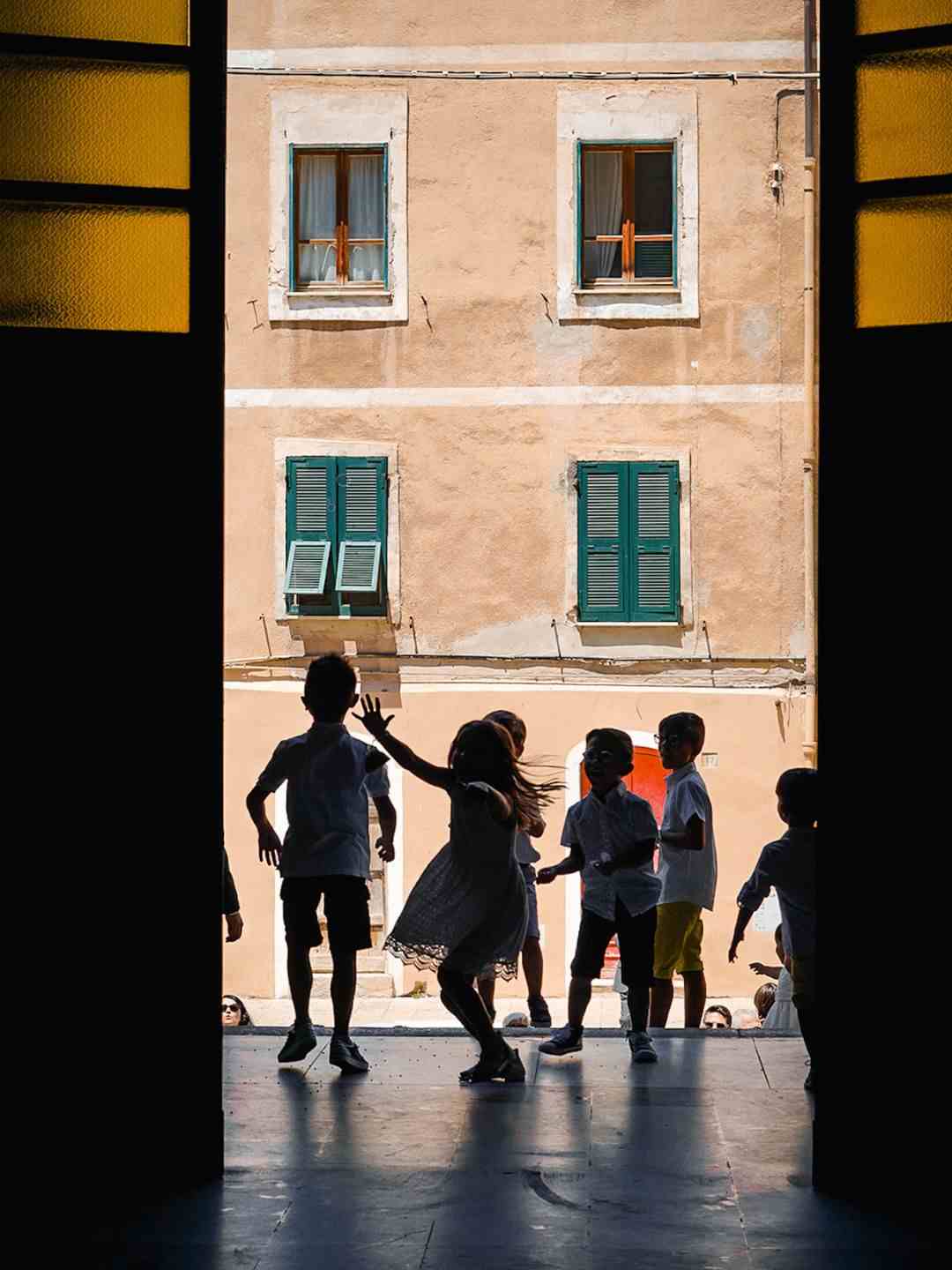 Bambini giocano all'uscita della Chiesa di Santa Caterina a Sassari