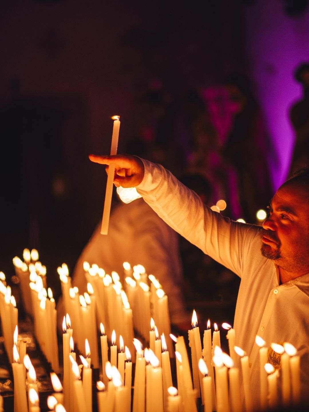 Uomo accende le candele durante la Settimana Santa a Sassari